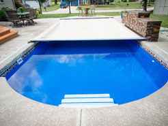 Retractable Swimming Pool Cover shown on an in ground pool.